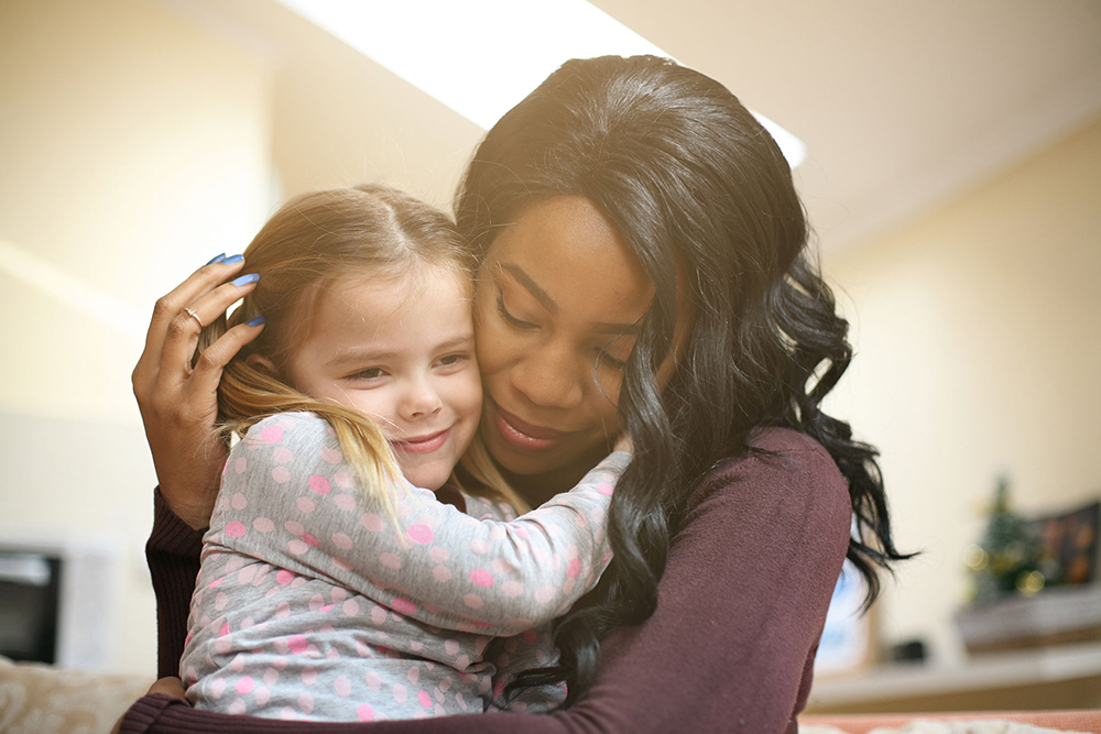 woman holding little girl in her arms image